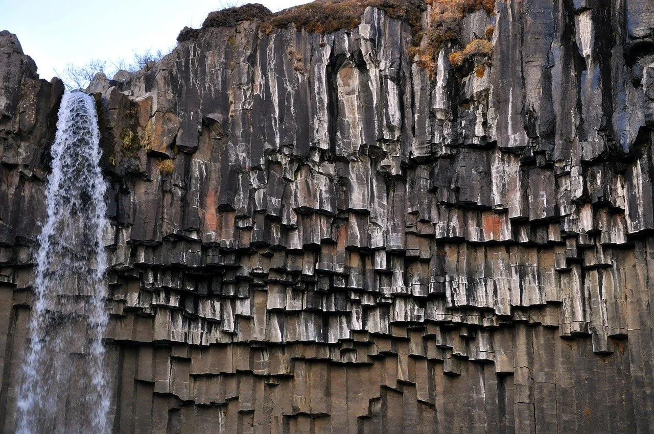 A close-up image of dark basalt rock behind Svartifoss by photographer KStreck